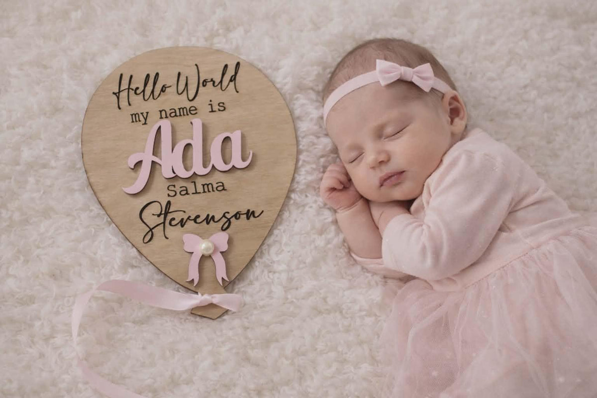 Newborn photo prop with personalised Hello World wooden balloon plaque and 3D baby name.