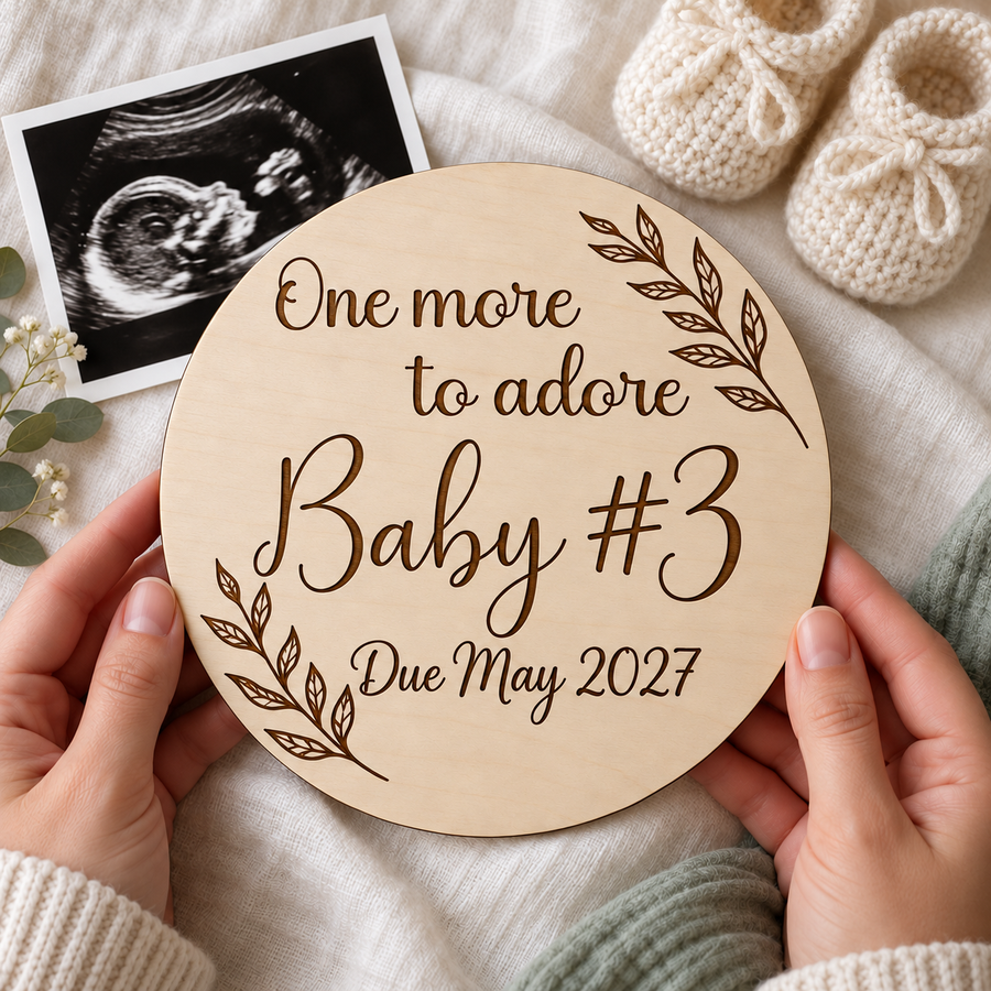 One more to adore pregnancy announcement plaque engraved Baby #3 held beside an ultrasound scan