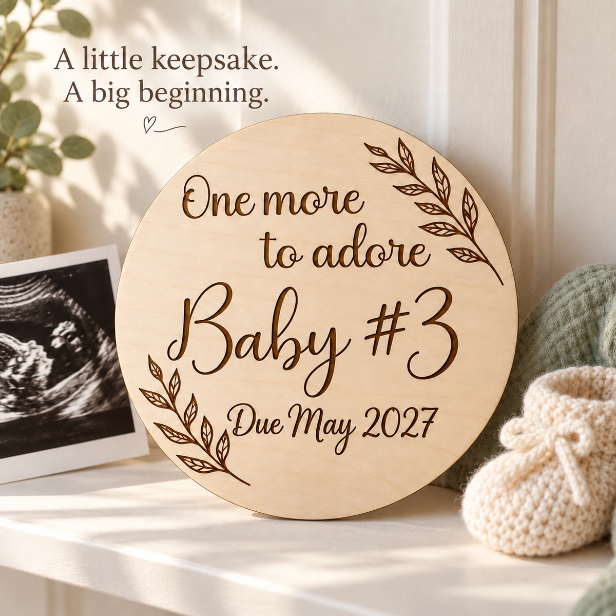 One more to adore Baby #3 keepsake displayed with an ultrasound scan