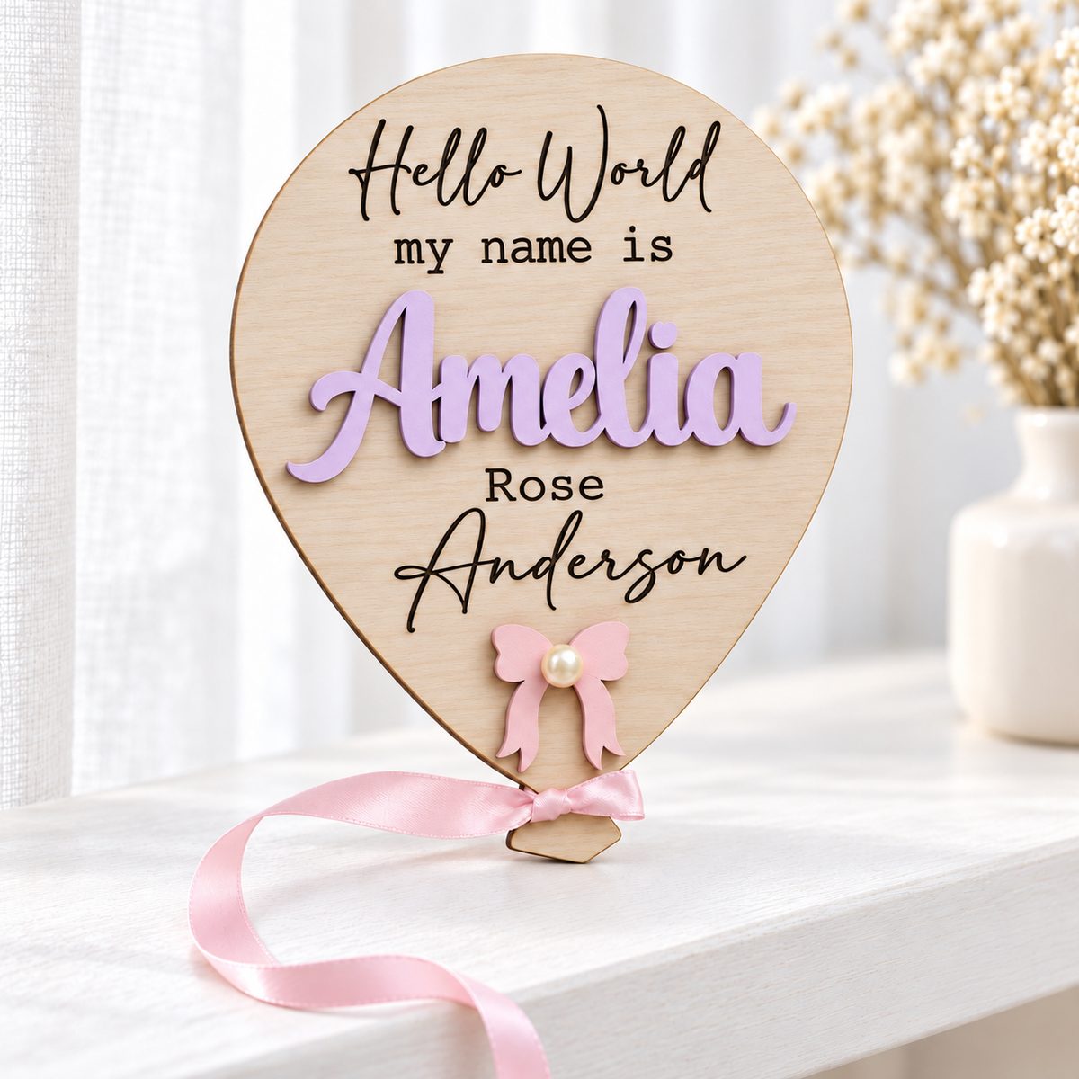 Light Violet Amelia balloon name plaque with engraved Rose Anderson, pink bow and pearl-effect centre.