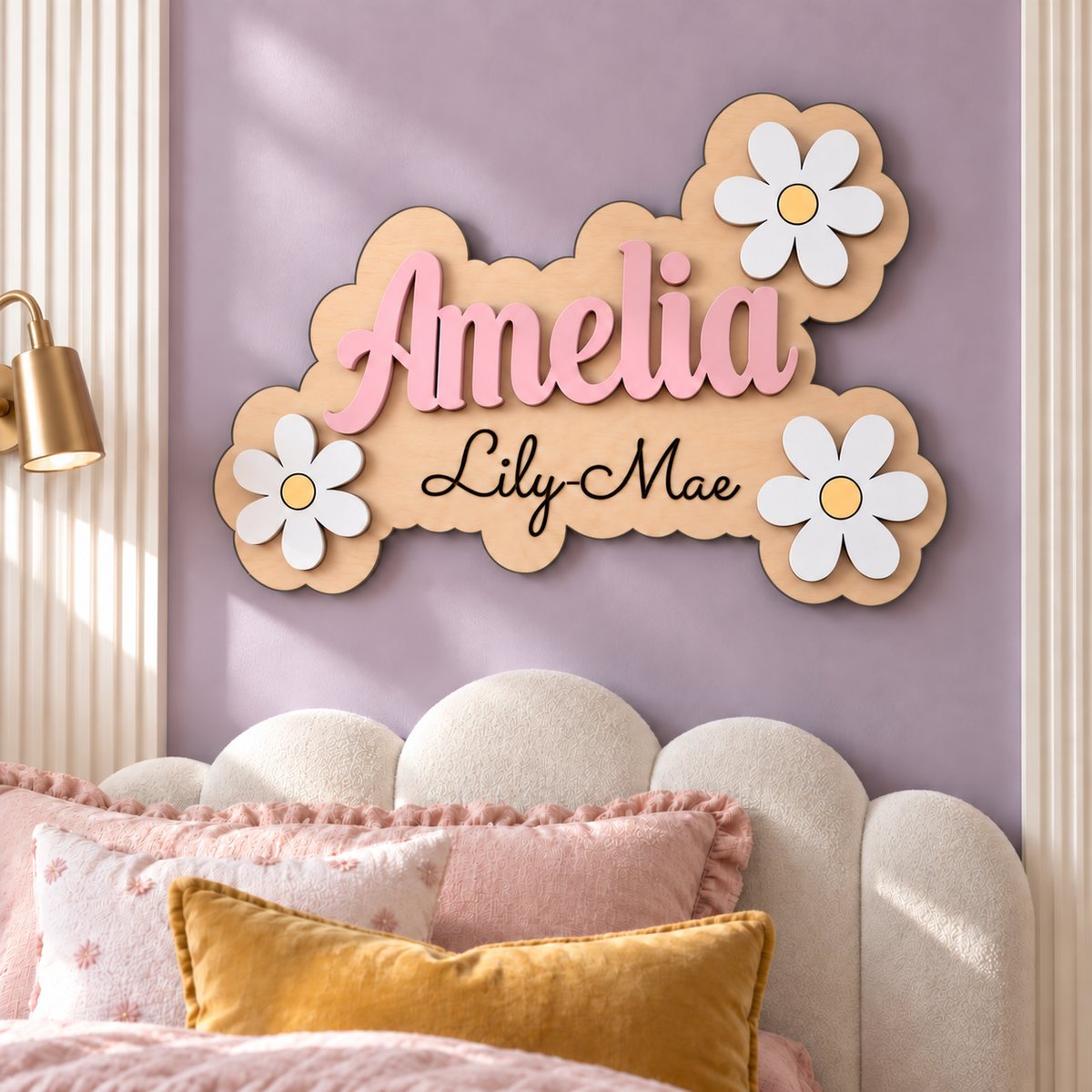 Amelia and Lily-Mae layered wooden name sign with pastel pink lettering and white daisies above a bed in a lavender bedroom.