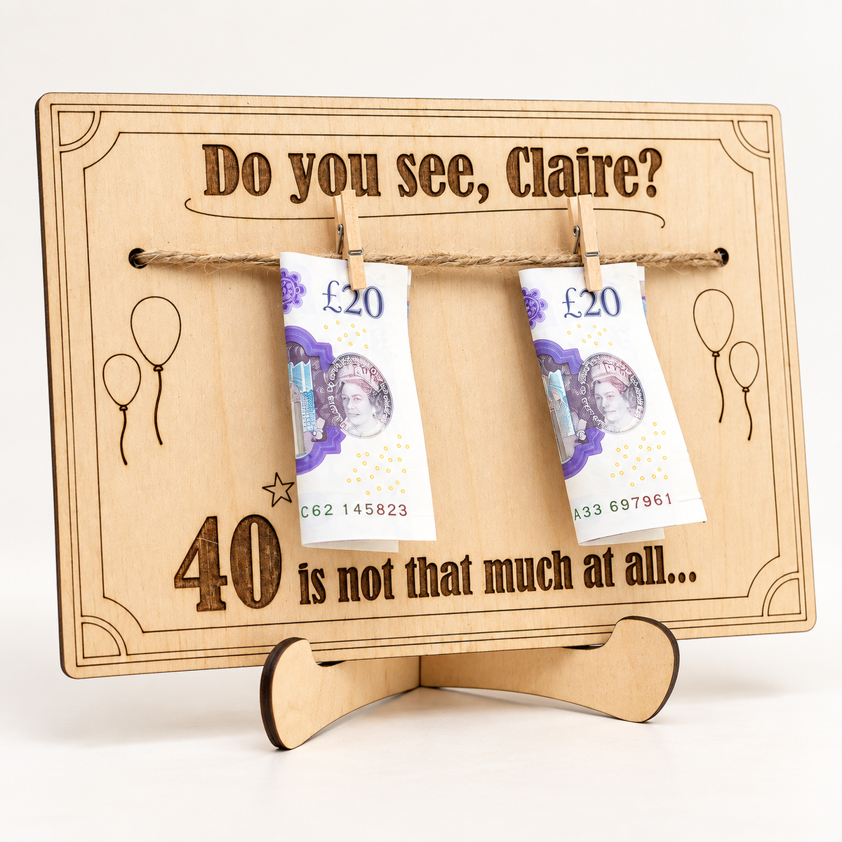 Personalised wooden birthday money holder for Claire's 40th birthday, with two banknotes clipped to twine and a display stand