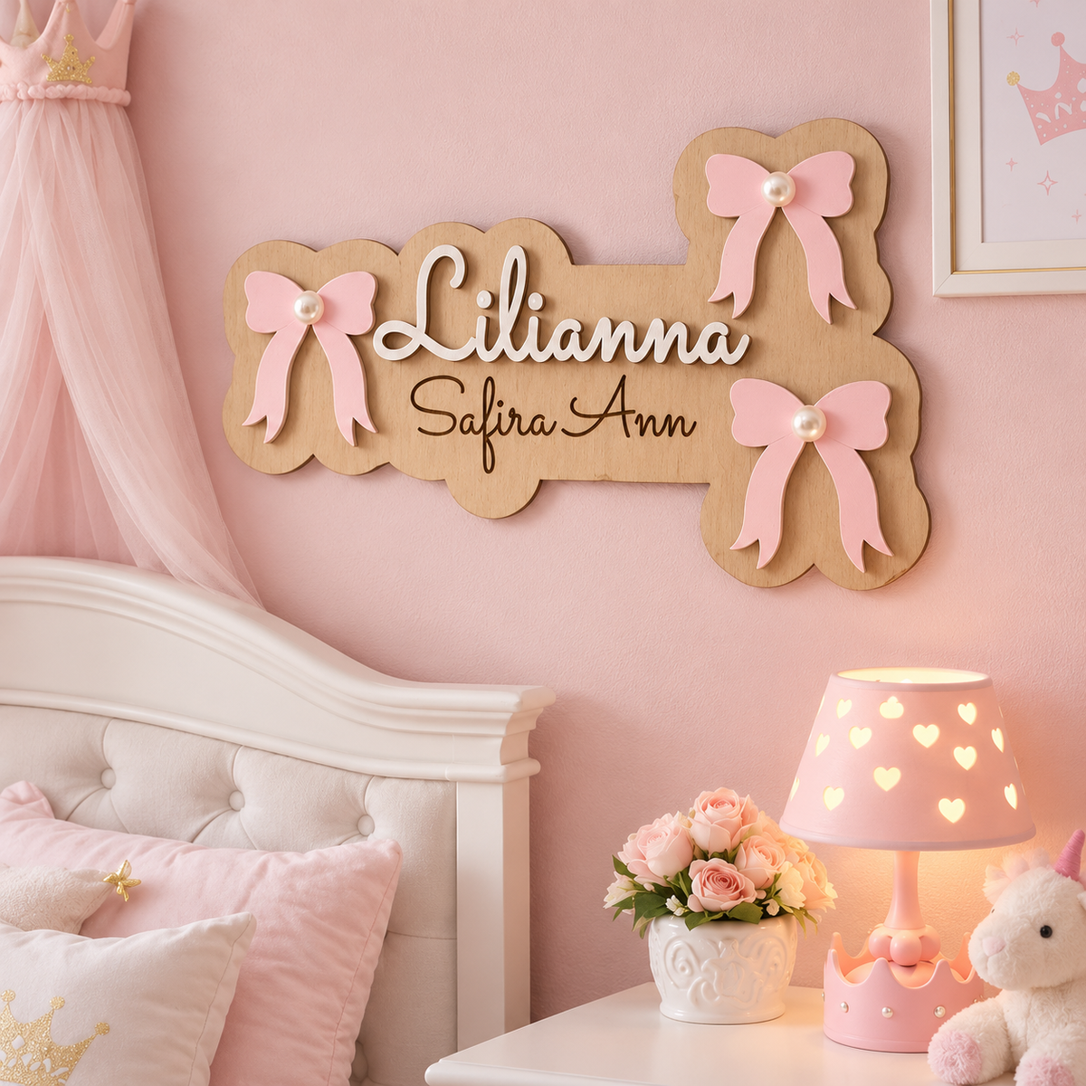Lilianna personalised wooden name plaque on a blush pink nursery wall, decorated with three pearl-centred pink bows.