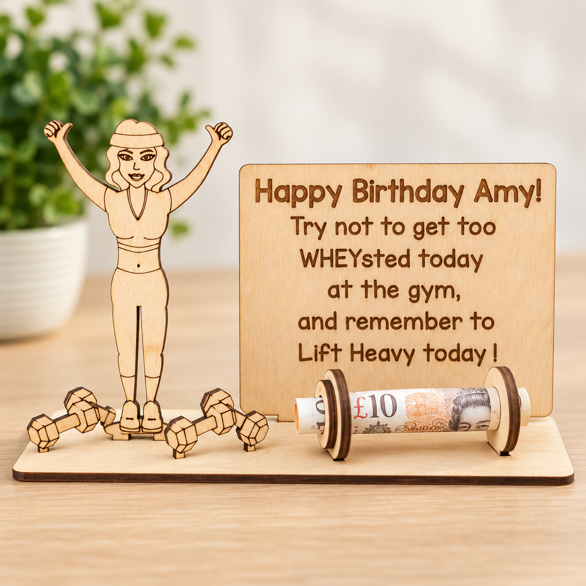 Personalised wooden gym money holder for women with engraved birthday message and a rolled banknote