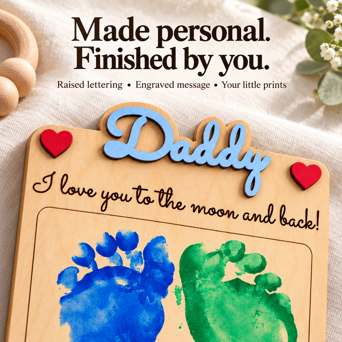 Close-up of blue raised Daddy lettering, red wooden hearts and dark personalised engraving on the wooden keepsake plaque.
