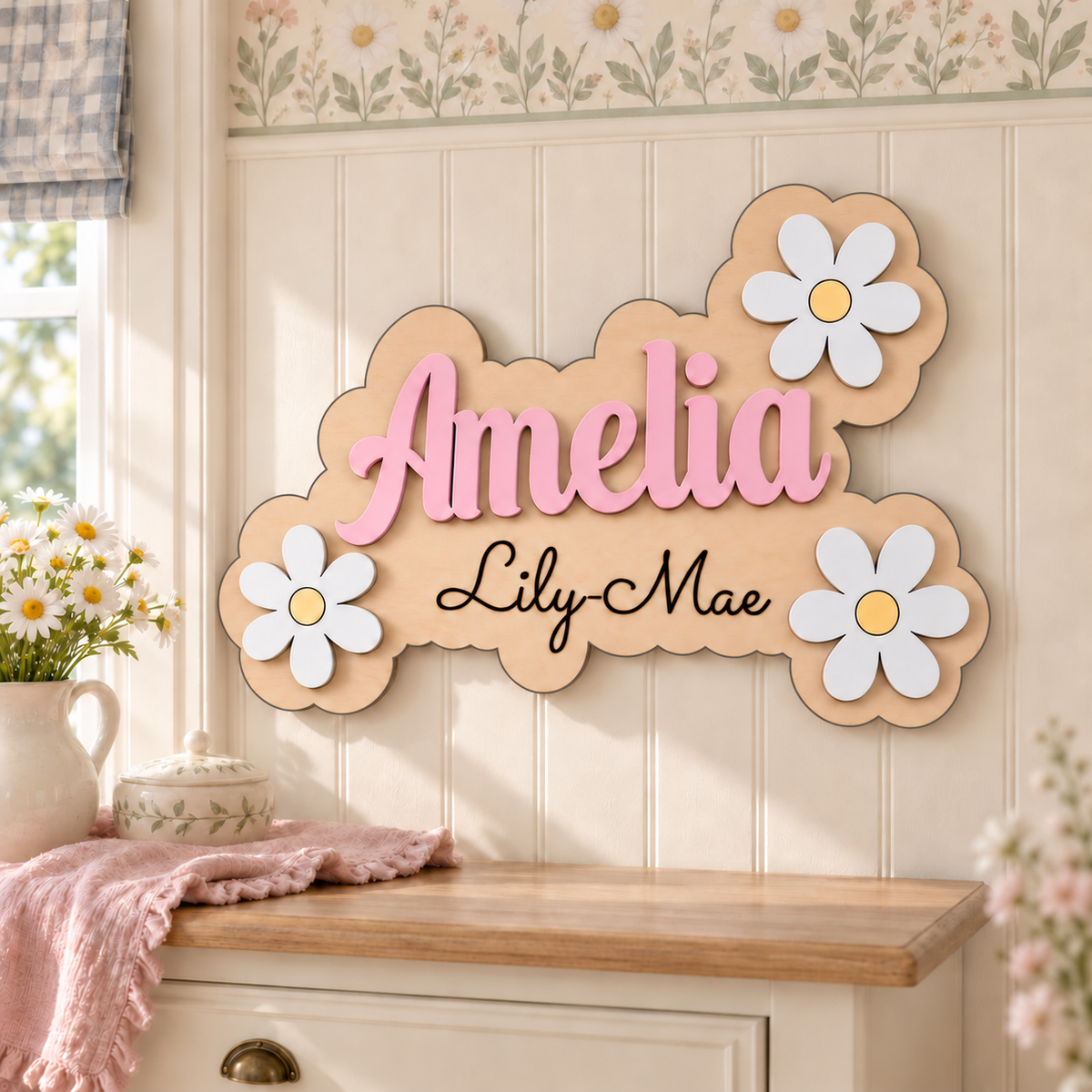 Personalised Amelia wooden name plaque with black Lily-Mae engraving and three white daisies, displayed in a floral bedroom.