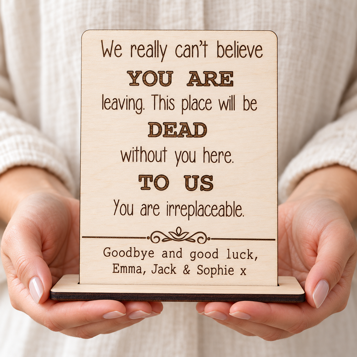 Personalised wooden leaving card held in hands, engraved with a farewell message