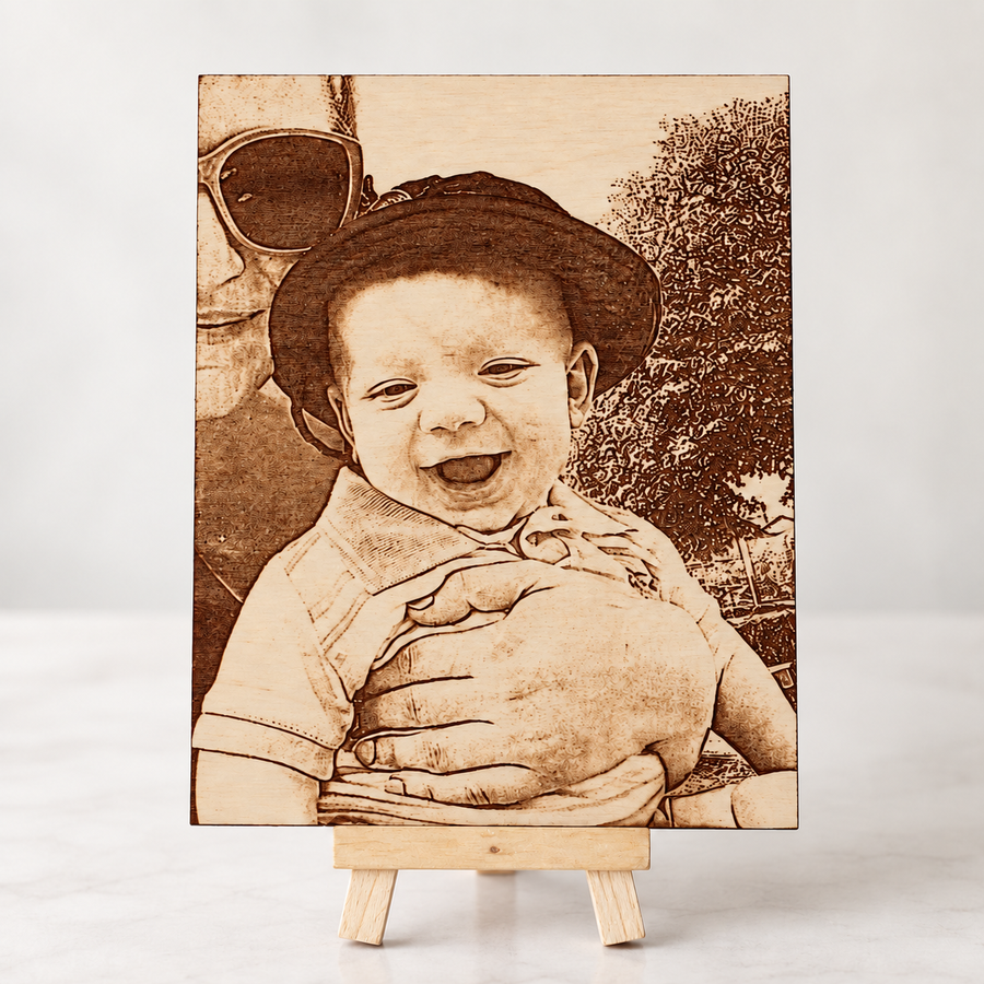 Baby portrait laser engraved in brown tones on a birch wood photo plaque, displayed on a mini wooden easel