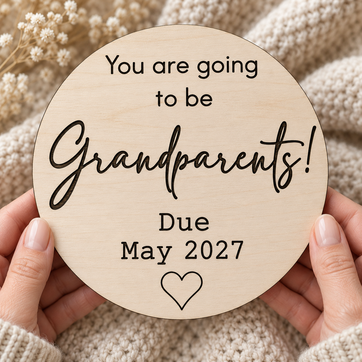 Grandparents pregnancy reveal plaque held in hands with example due date May 2027