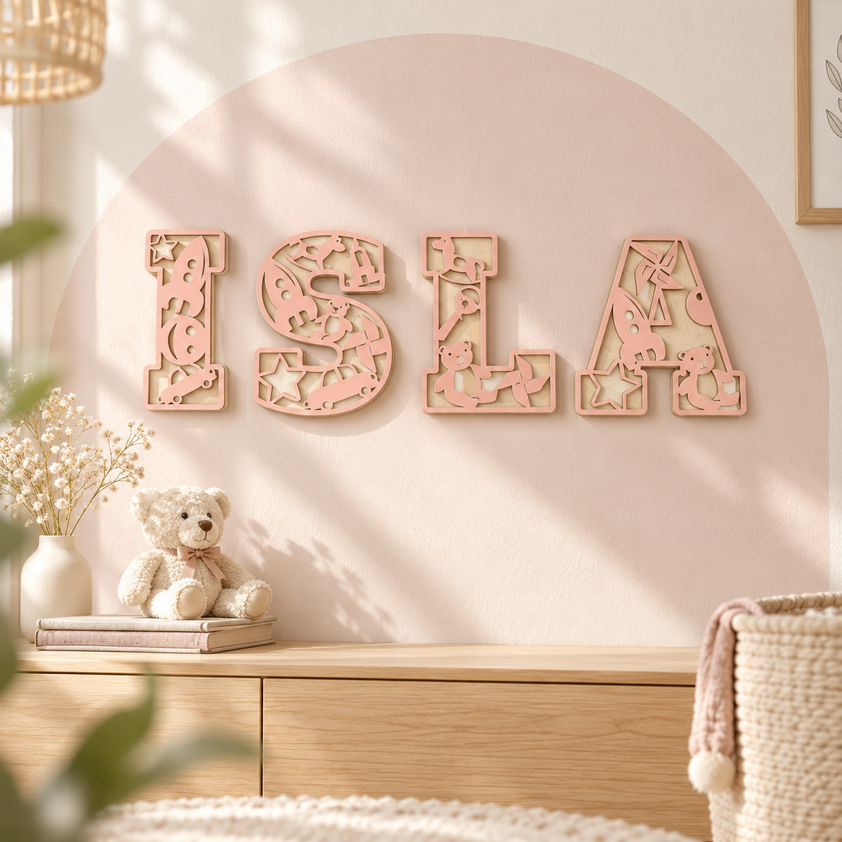 Pastel Pink ISLA personalised wooden name letters with toy cutout details and natural birch backing on a nursery wall