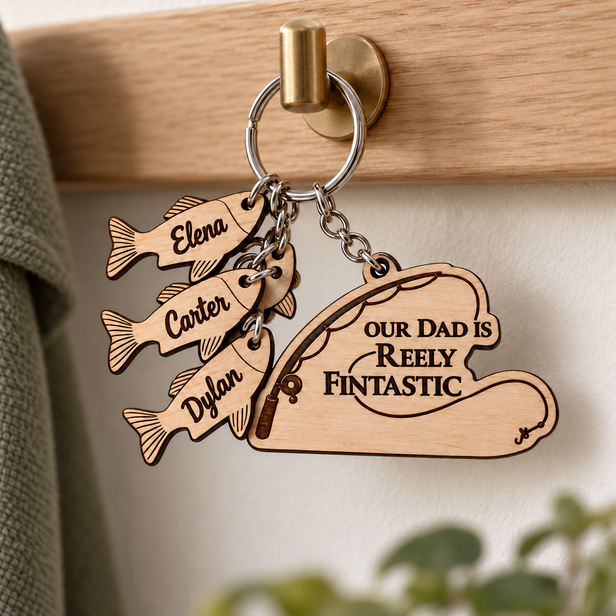 Our Dad is Reely Fintastic keyring with named fish charms hanging from a brass hallway hook