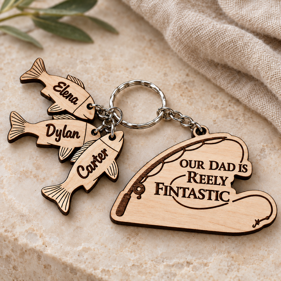 Our Dad is Reely Fintastic personalised fishing keyring with Carter, Elena and Dylan wooden fish charms on a stone background