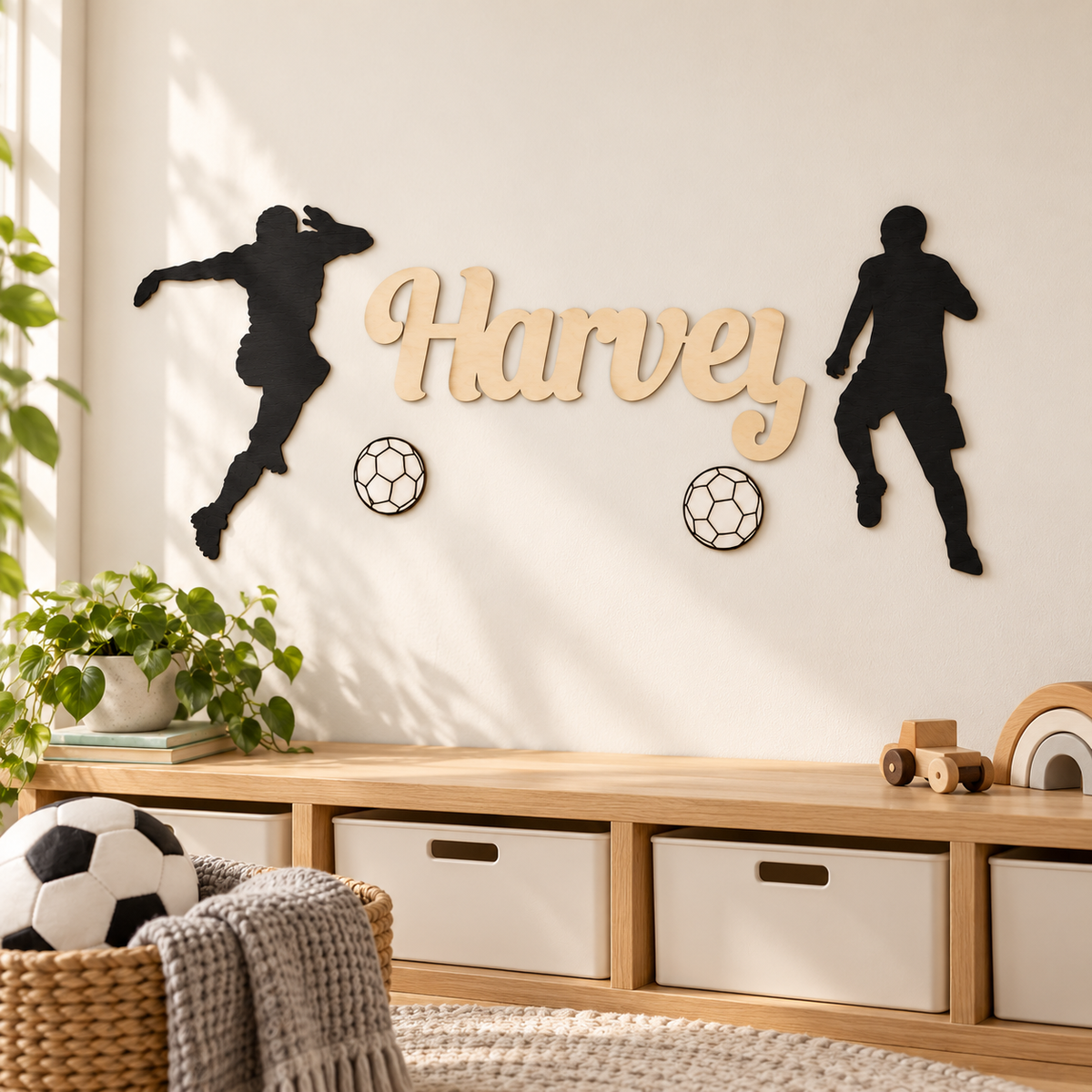 Unpainted natural birch Harvey name with two black football players and two white footballs in a child's room.