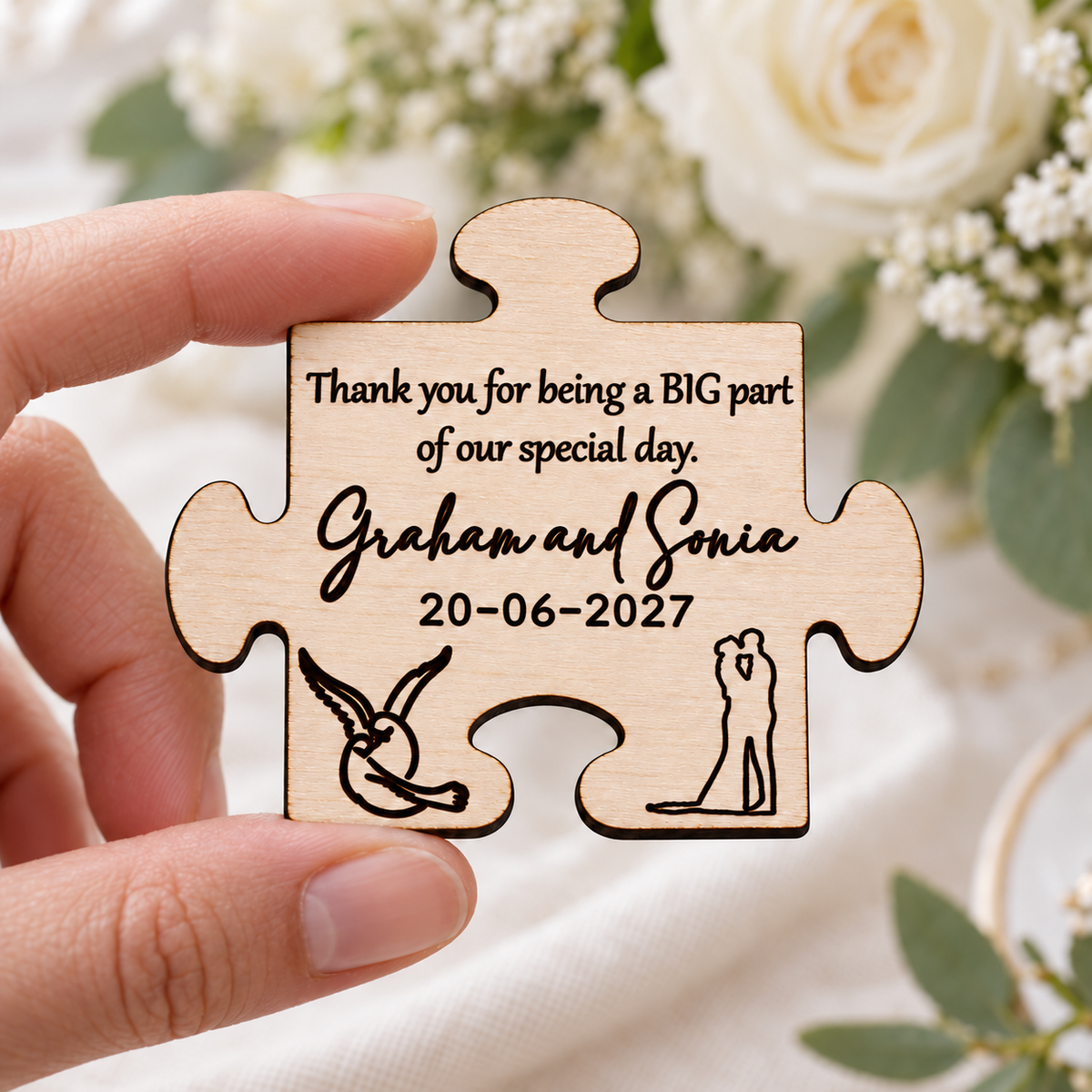 Small personalised wooden wedding favour magnet held in a hand to show its approximate size.