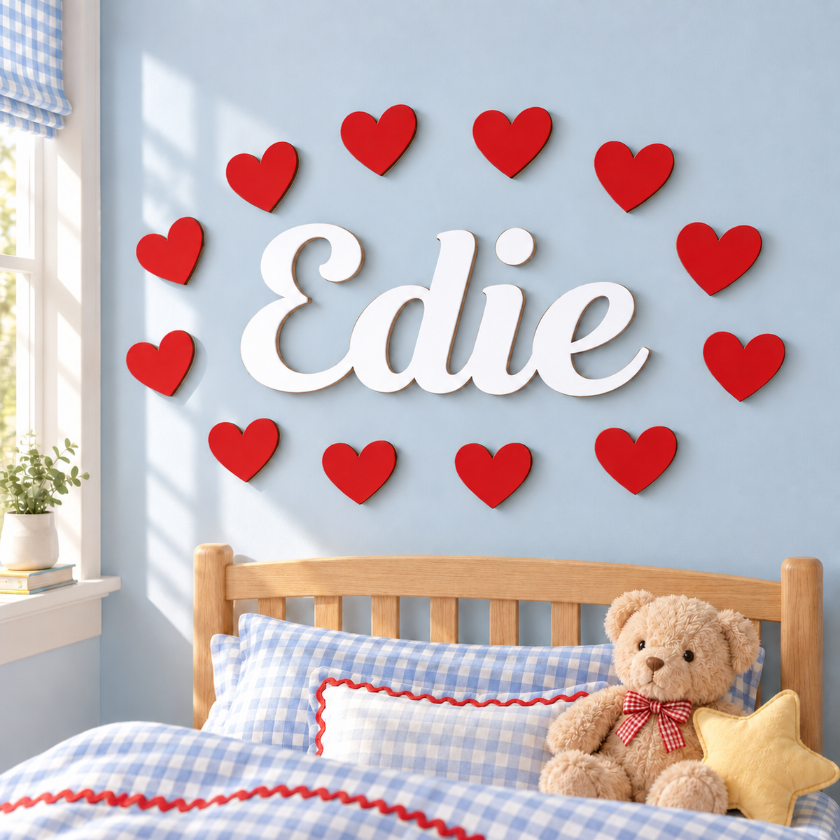 White wooden name sign Edie surrounded by 12 red hearts on a blue children's bedroom wall