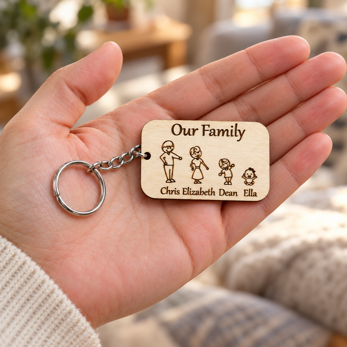 Four-character Our Family wooden keyring held in an adult hand, with engraved names Chris, Elizabeth, Dean and Ella