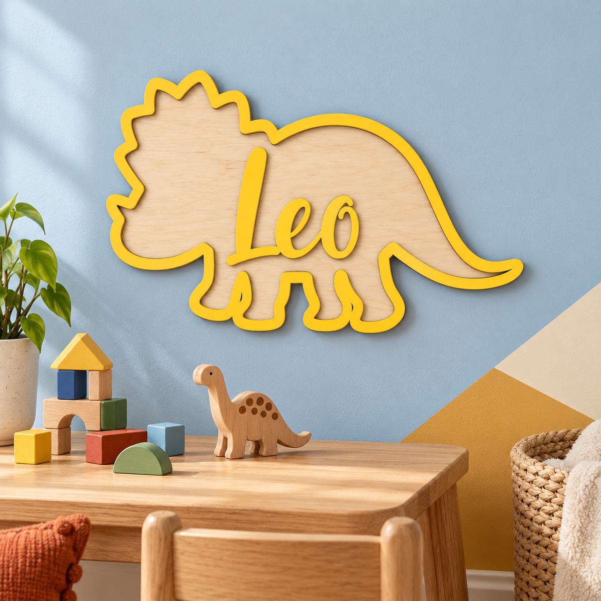 Yellow Leo wooden triceratops name plaque above an oak activity table in a child's playroom.