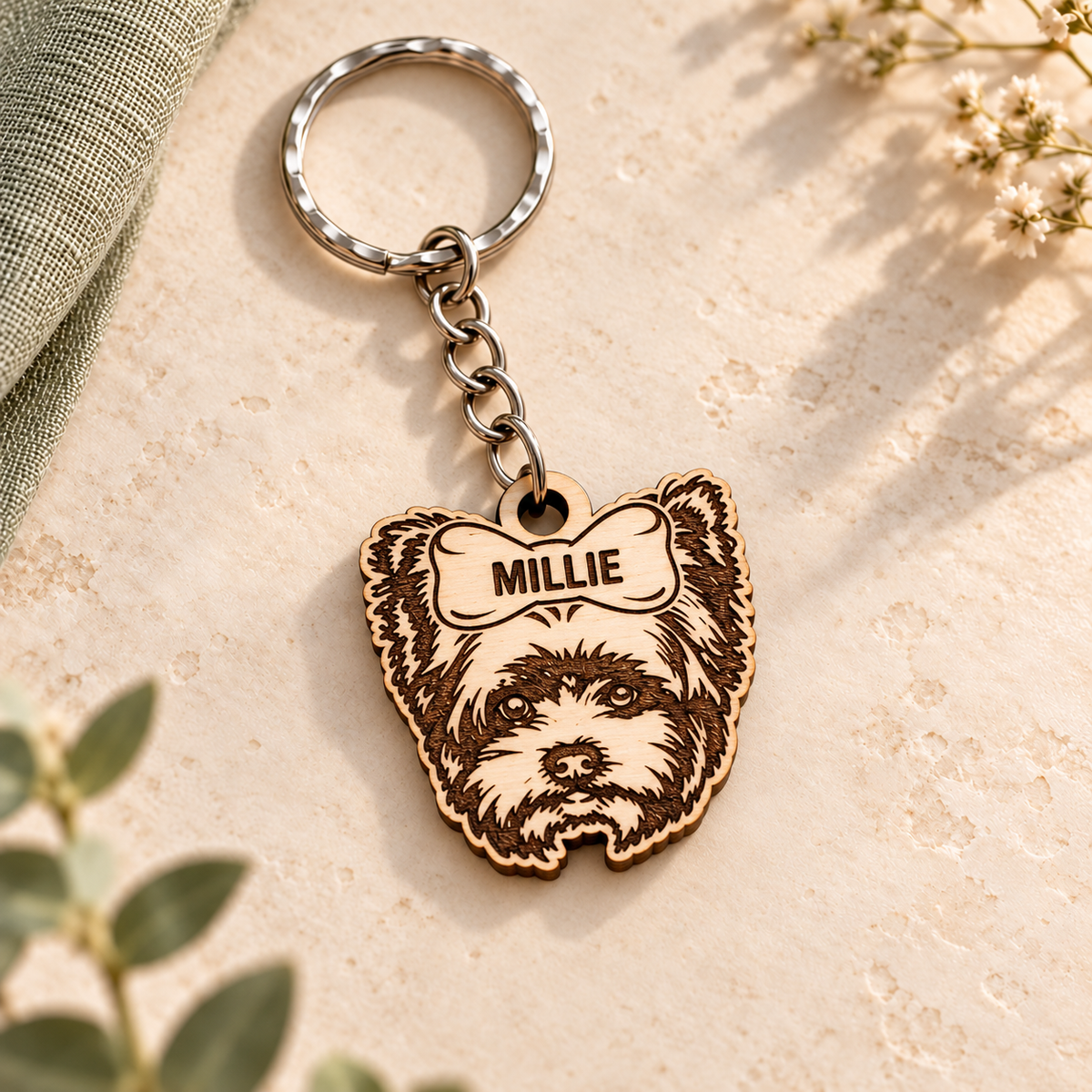 Wooden Yorkshire Terrier keyring with MILLIE engraved on the top bow, silver chain and split ring on cream stone